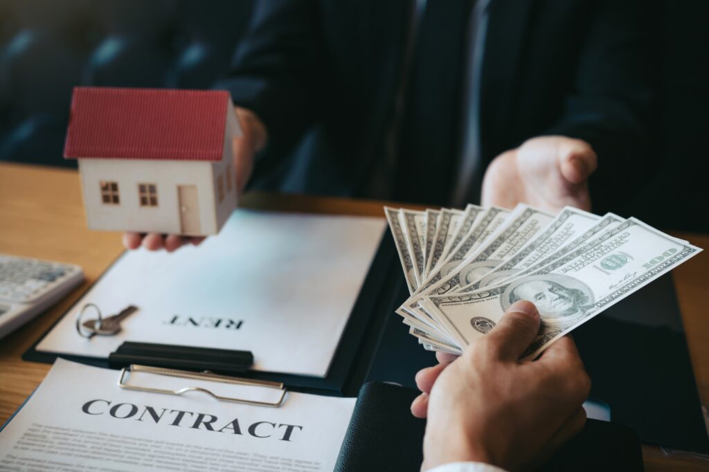 Businessman handed the money new home and real estate trading concepts.